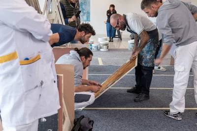 Docente e partecipanti osservano da vicino una finitura effetto ruggine